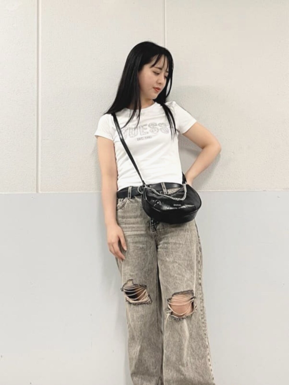 グレー系のデニムパンツ、ブラック系のハンドバッグ、ホワイト系のTシャツ/カットソーを着用したレディースの夏コーディネートの4枚目の写真