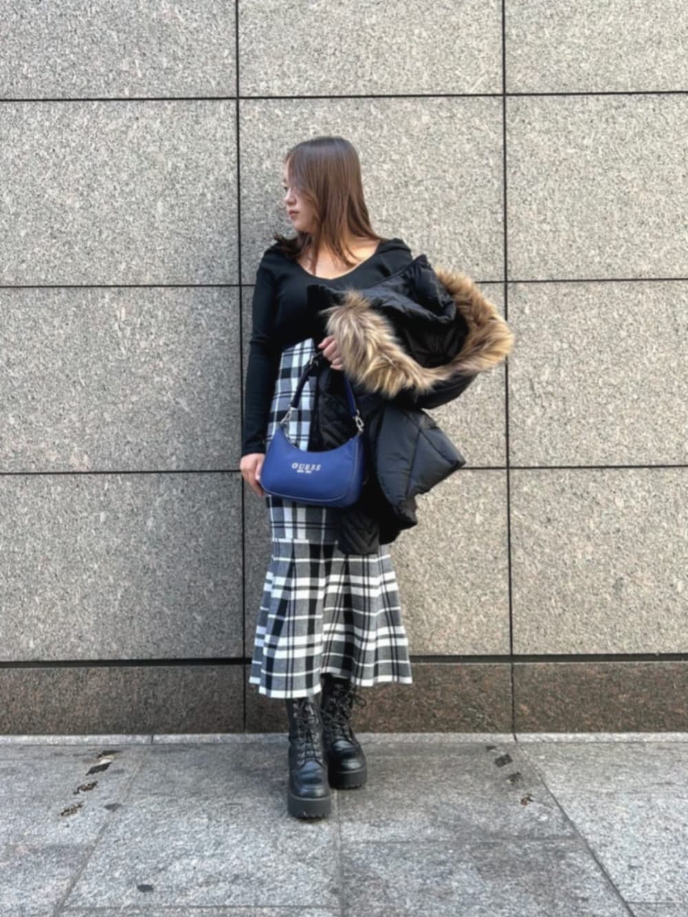 ブラック系のワンピース、ブルー系のショルダーバッグ、ブラック系のダウンジャケット/コートを着用したレディースの冬コーディネートの4枚目の写真