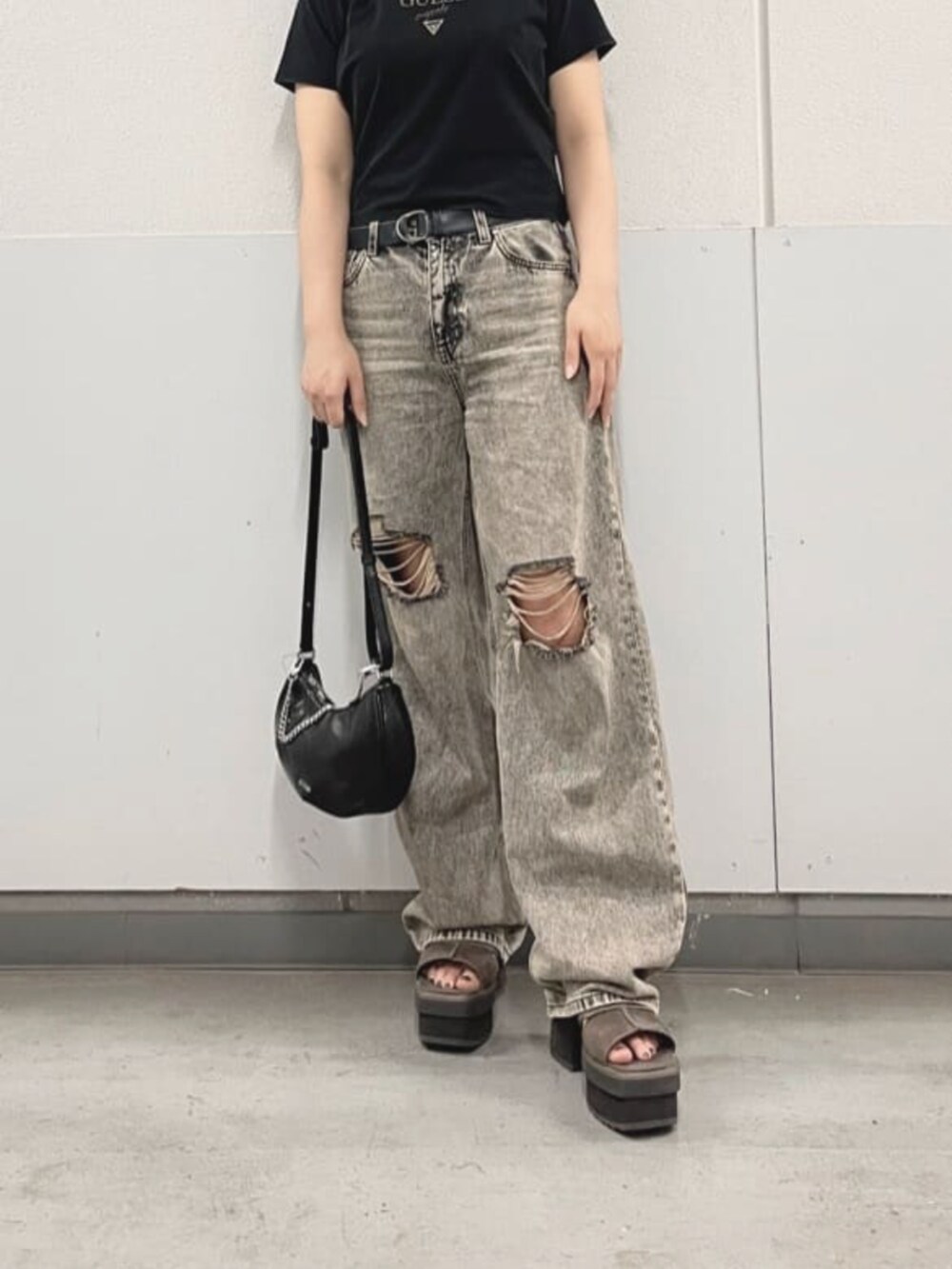 グレー系のデニムパンツ、ブラック系のTシャツ/カットソー、ブラック系のハンドバッグを着用したレディースの夏コーディネートの4枚目の写真