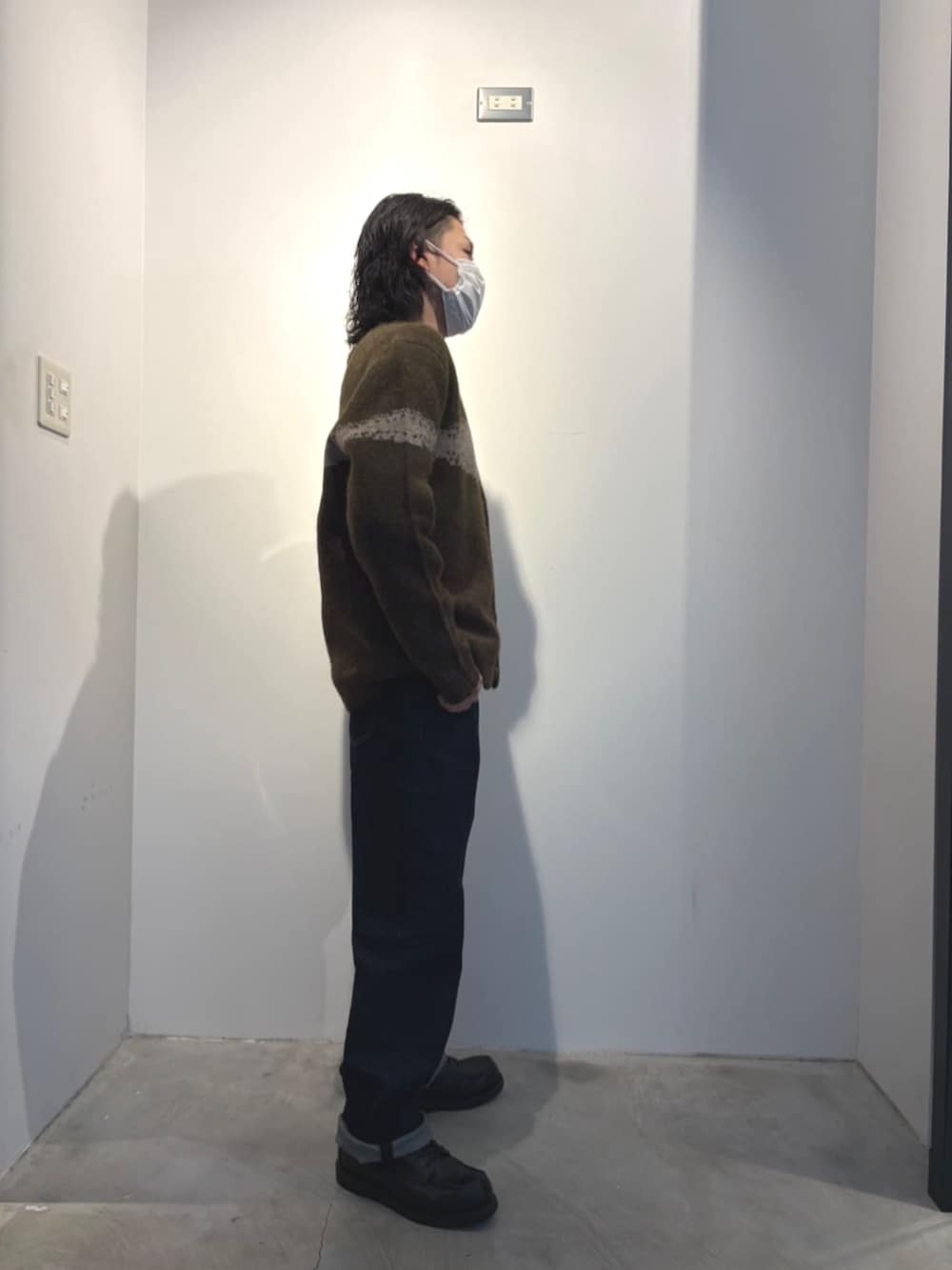 ブルー系のデニムパンツ、グリーン系のカーディガン/ボレロを着用したメンズの冬コーディネートの3枚目の写真