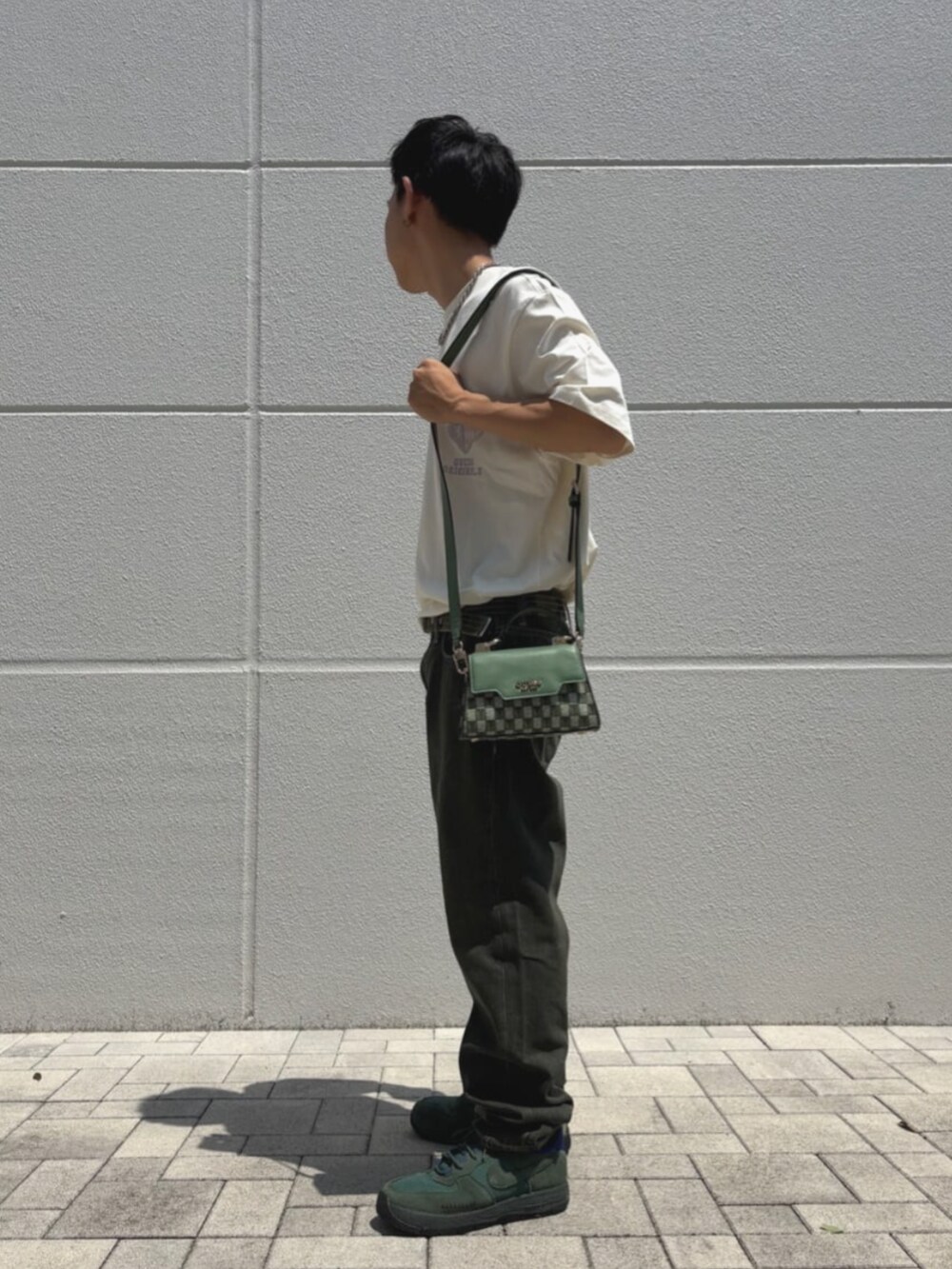 グリーン系のハンドバッグを着用したメンズの夏コーディネートの3枚目の写真