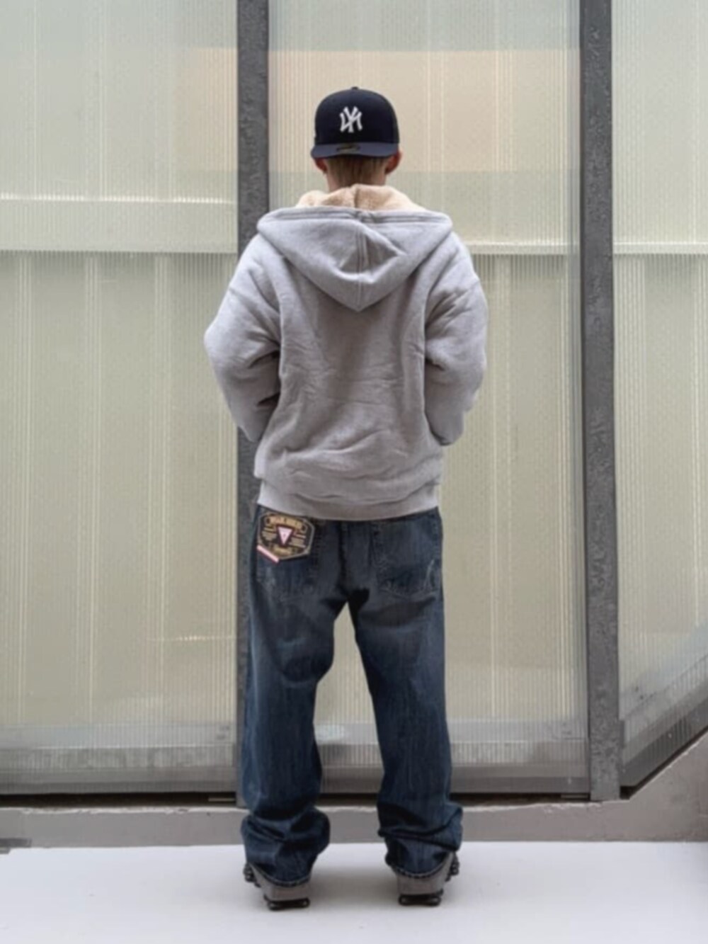 ブラック系のTシャツ/カットソー、ブルー系のデニムパンツ、グレー系のパーカーを着用したメンズの冬コーディネートの2枚目の写真