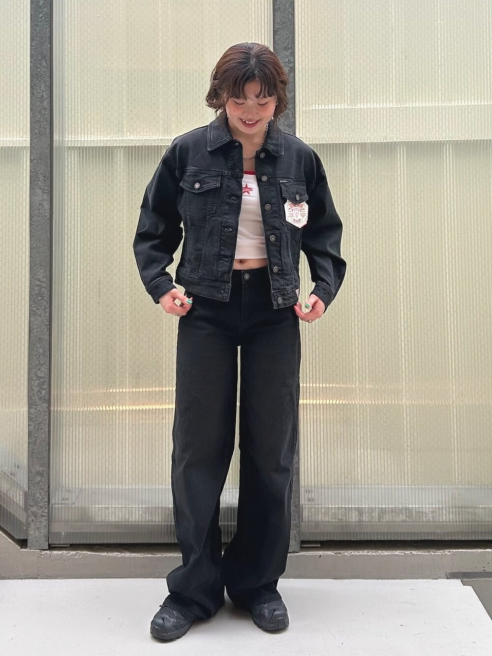 ブルー系のデニムパンツ、ホワイト系のキャミソール、ブルー系のデニムジャケットを着用したレディースの夏コーディネートの4枚目の写真