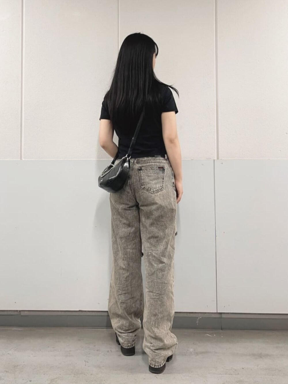 グレー系のデニムパンツ、ブラック系のTシャツ/カットソー、ブラック系のハンドバッグを着用したレディースの夏コーディネートの2枚目の写真