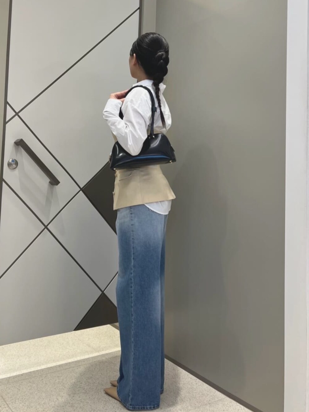 ブラック系のショルダーバッグ、ホワイト系のシャツ/ブラウス、ブルー系のデニムパンツを着用したレディースの夏コーディネートの3枚目の写真