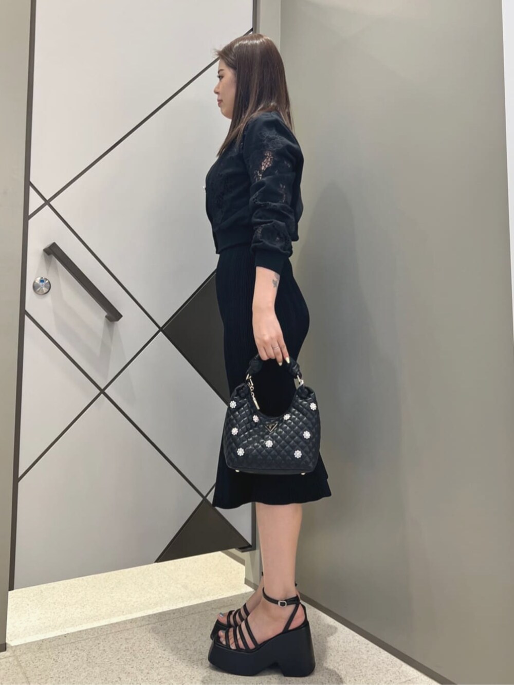 ブラック系のワンピース、ブラック系のショルダーバッグを着用したレディースの夏コーディネートの3枚目の写真