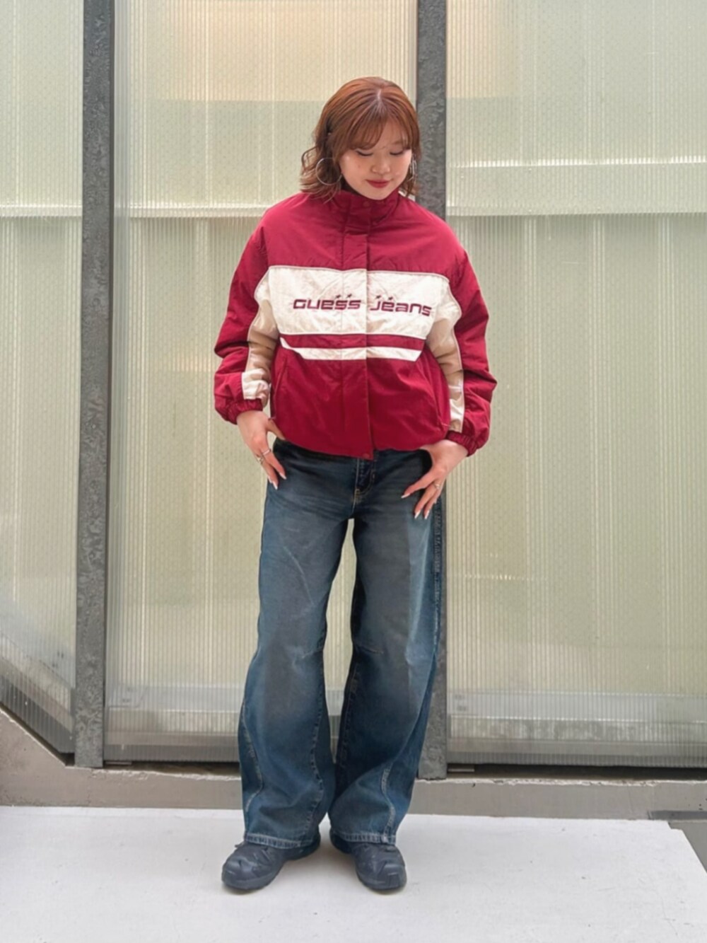 ブルー系のデニムパンツ、レッド系のナイロンジャケットを着用したレディースの冬コーディネートの4枚目の写真