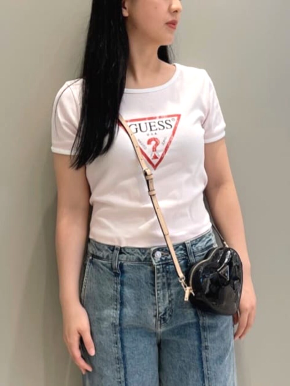 ブラック系のショルダーバッグ、ブルー系のデニムパンツ、ピンク系のTシャツ/カットソーを着用したレディースの夏コーディネートの4枚目の写真