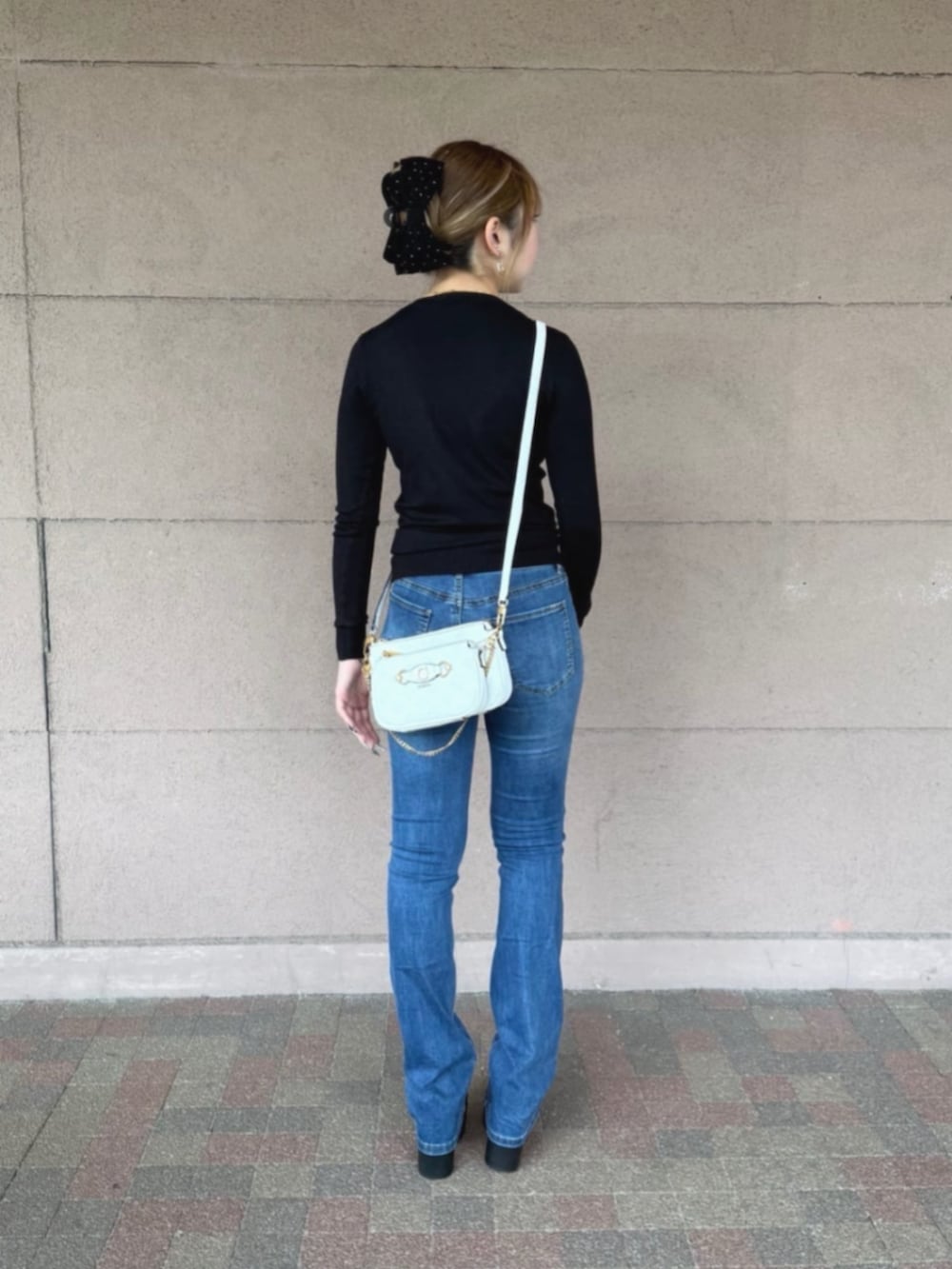 ホワイト系のショルダーバッグ、ブラック系のTシャツ/カットソーを着用したレディースの秋コーディネートの2枚目の写真