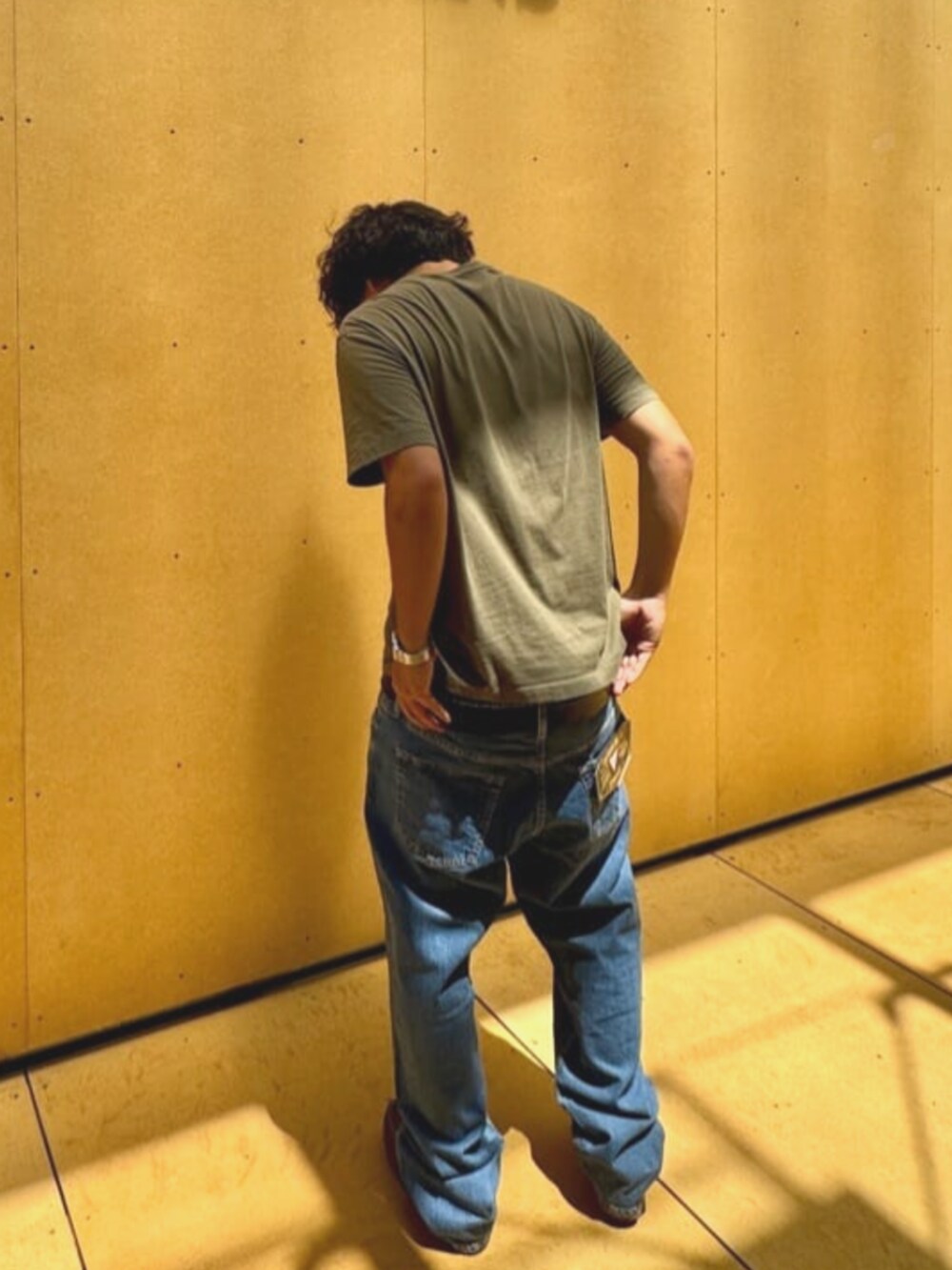 グリーン系のTシャツ/カットソー、ブルー系のデニムパンツを着用したメンズの夏コーディネートの2枚目の写真