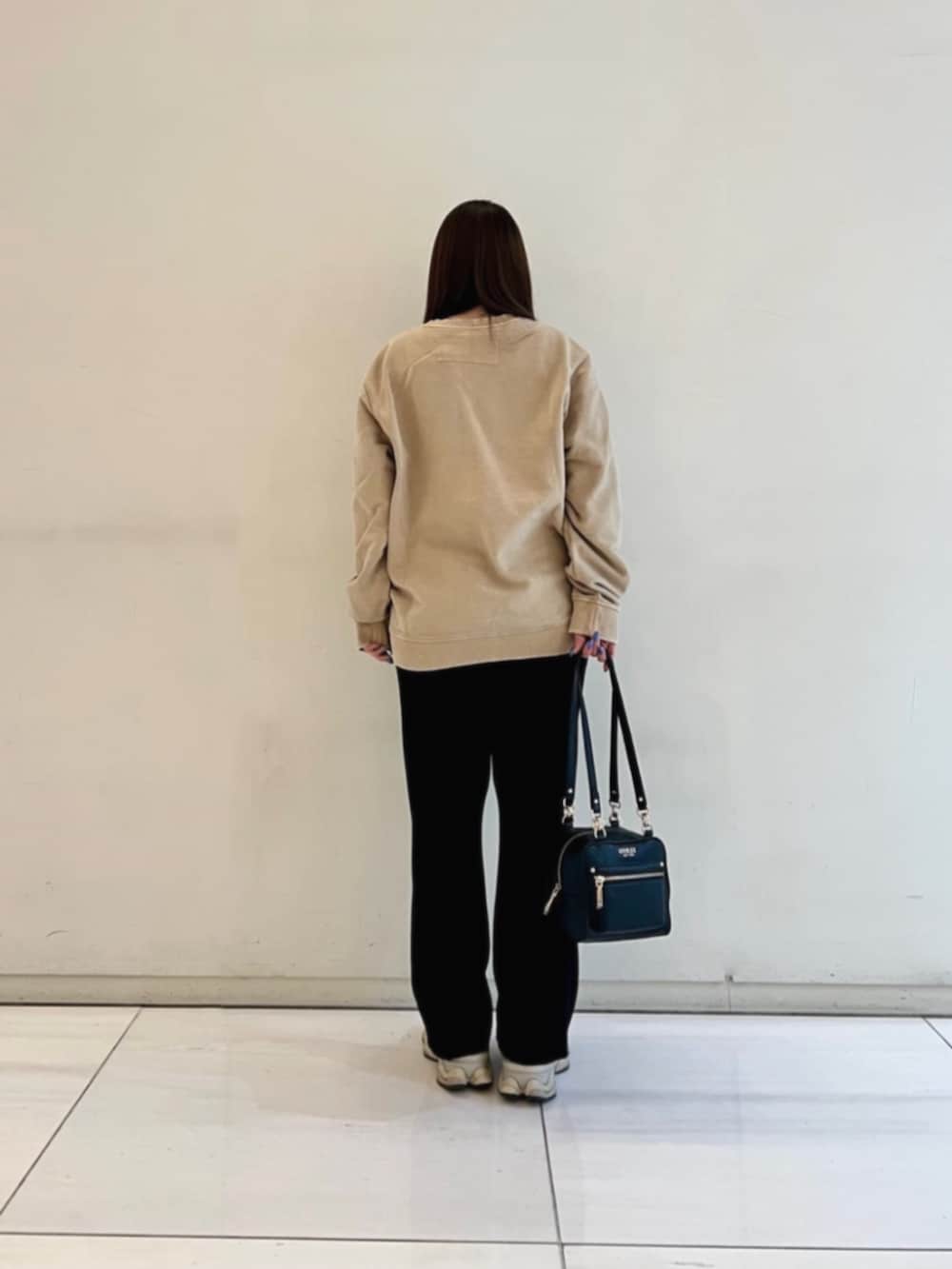 ブラック系のショルダーバッグ、ベージュ系のスウェットを着用したレディースの冬コーディネートの2枚目の写真