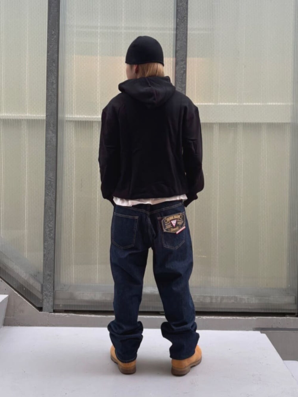 ブルー系のデニムパンツ、ホワイト系のTシャツ/カットソー、ブラック系のパーカーを着用したメンズの秋コーディネートの2枚目の写真