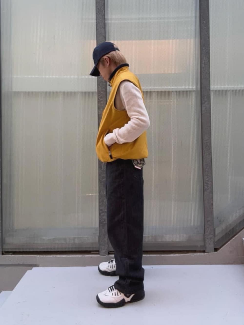 ブラック系のデニムパンツ、イエロー系のベスト、その他のボクサーパンツを着用したメンズの秋コーディネートの6枚目の写真