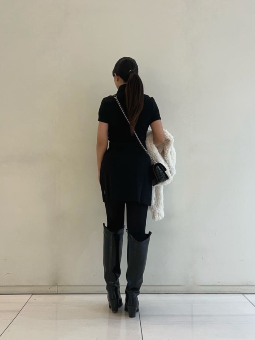 ブラック系のショルダーバッグ、ブラック系のスカート、ブラック系のシャツ/ブラウスを着用したレディースの冬コーディネートの2枚目の写真