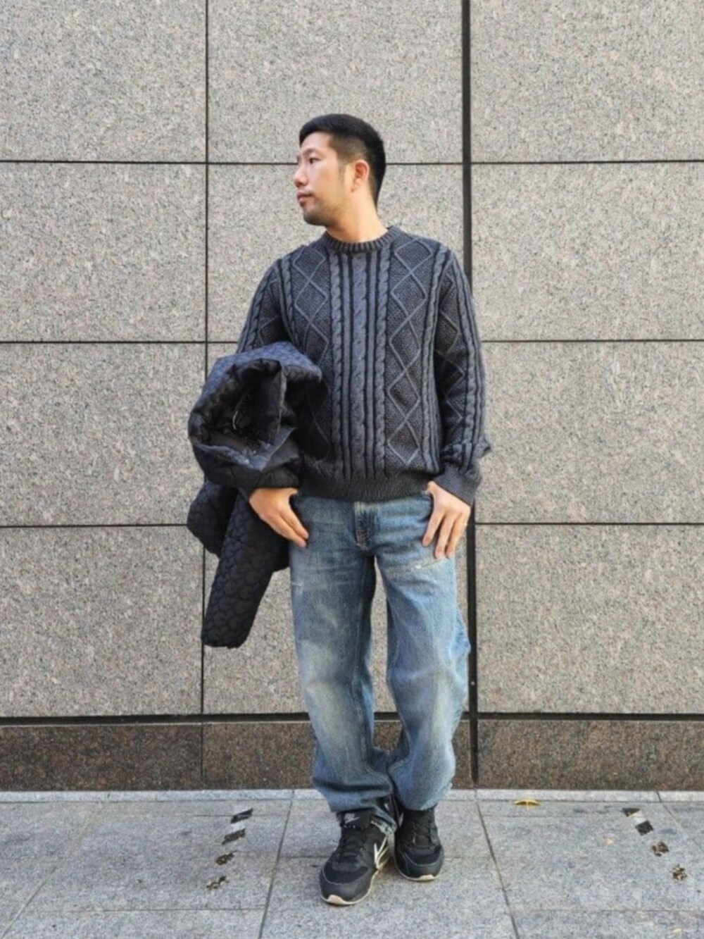 ブルー系のデニムパンツ、ブラック系のニット/セーター、ブラック系のその他アウターを着用したメンズの冬コーディネートの4枚目の写真