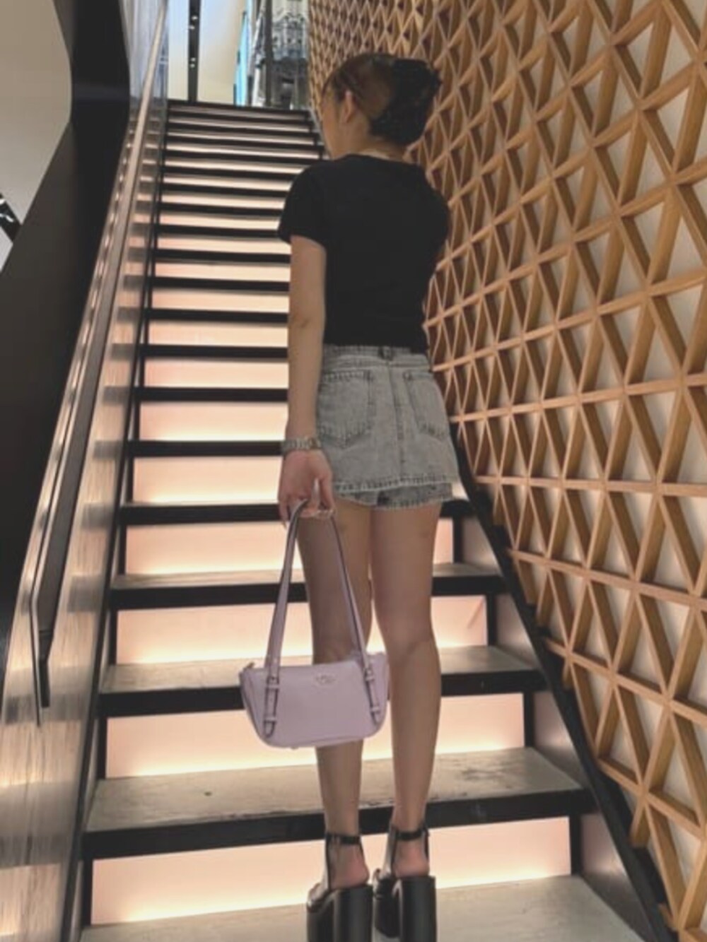 パープル系のショルダーバッグ、グレー系のデニムパンツを着用したレディースの夏コーディネートの2枚目の写真