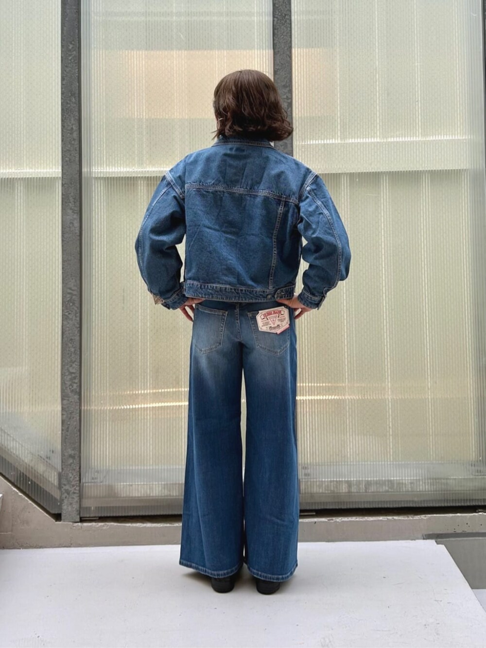 ブルー系のデニムパンツ、ピンク系のTシャツ/カットソー、ブルー系のデニムジャケットを着用したレディースの秋コーディネートの2枚目の写真