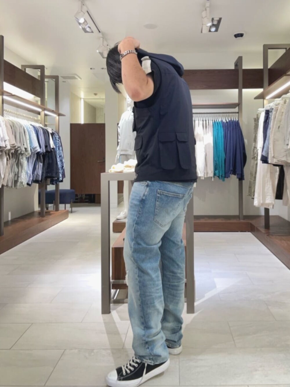 ブルー系のデニムパンツ、シルバー系のブレスレットを着用したメンズの夏コーディネートの3枚目の写真