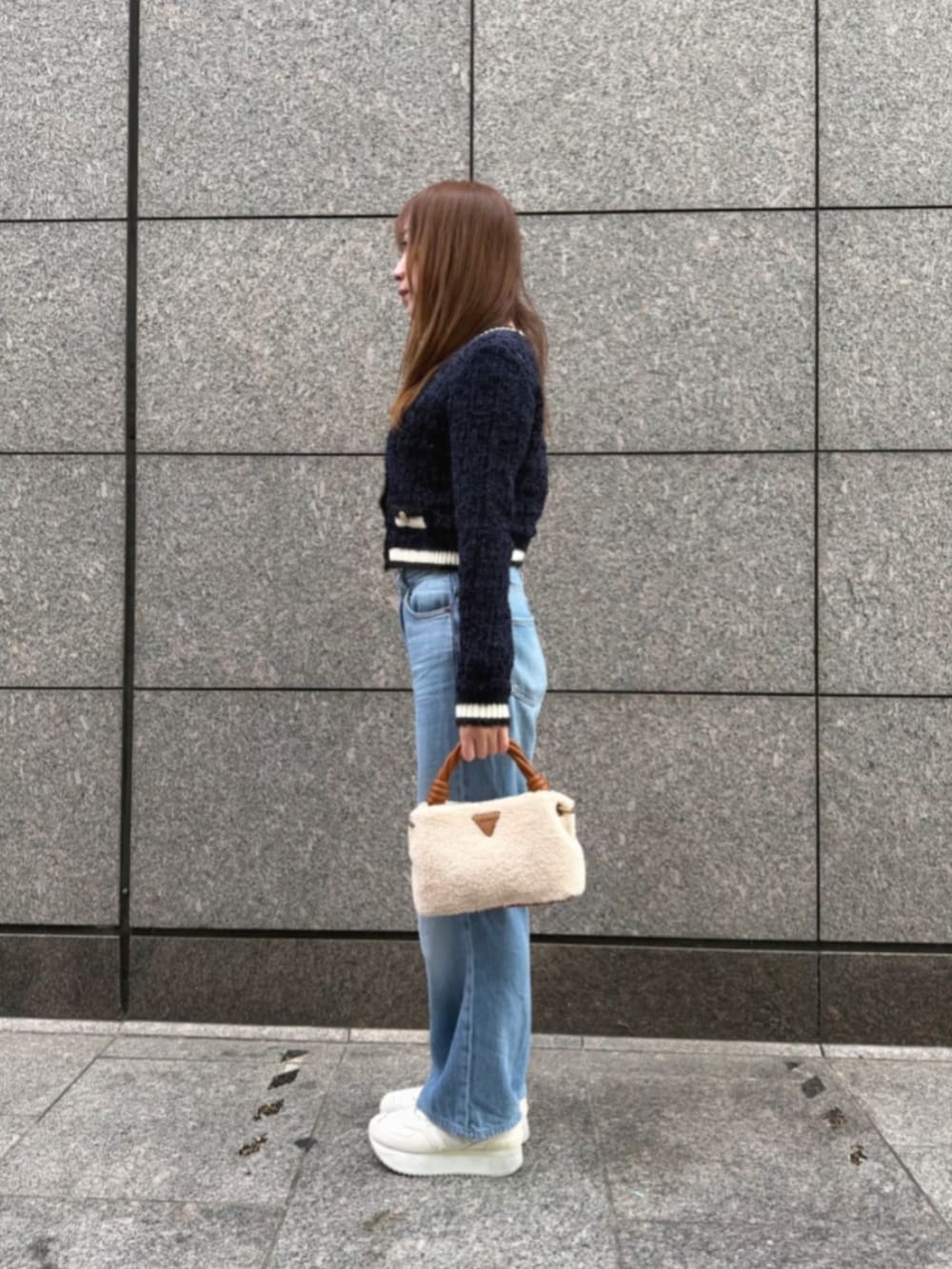 ブルー系のデニムパンツ、イエロー系のショルダーバッグ、ブルー系のカーディガン/ボレロを着用したレディースの冬コーディネートの3枚目の写真