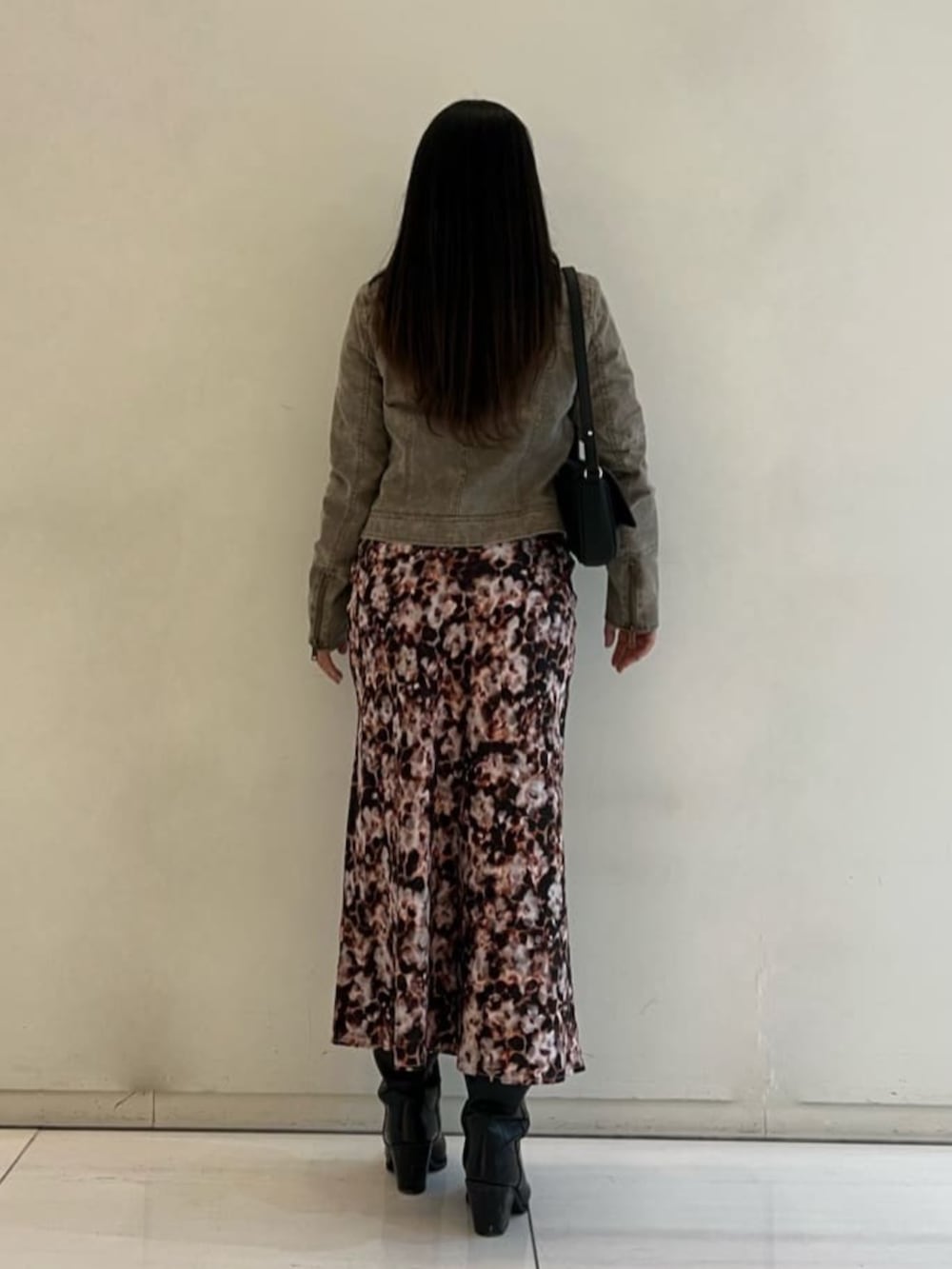 ベージュ系のノーカラージャケット、ブラック系のショルダーバッグ、ブラウン系のワンピースを着用したレディースの春コーディネートの2枚目の写真