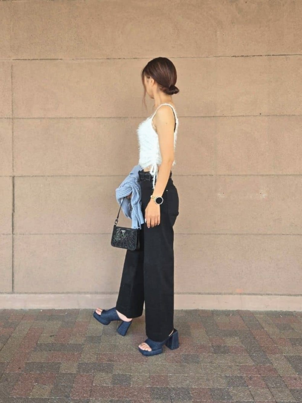 ブラック系のデニムパンツ、ブルー系のカーディガン/ボレロ、その他のキャミソールを着用したレディースの秋コーディネートの4枚目の写真