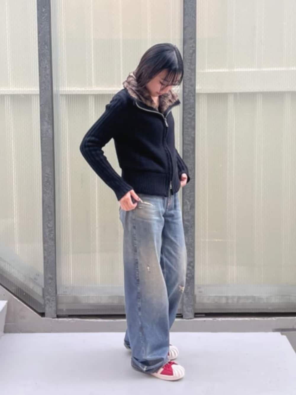 ブルー系のデニムパンツ、ブラック系のカーディガン/ボレロを着用したレディースの冬コーディネートの2枚目の写真