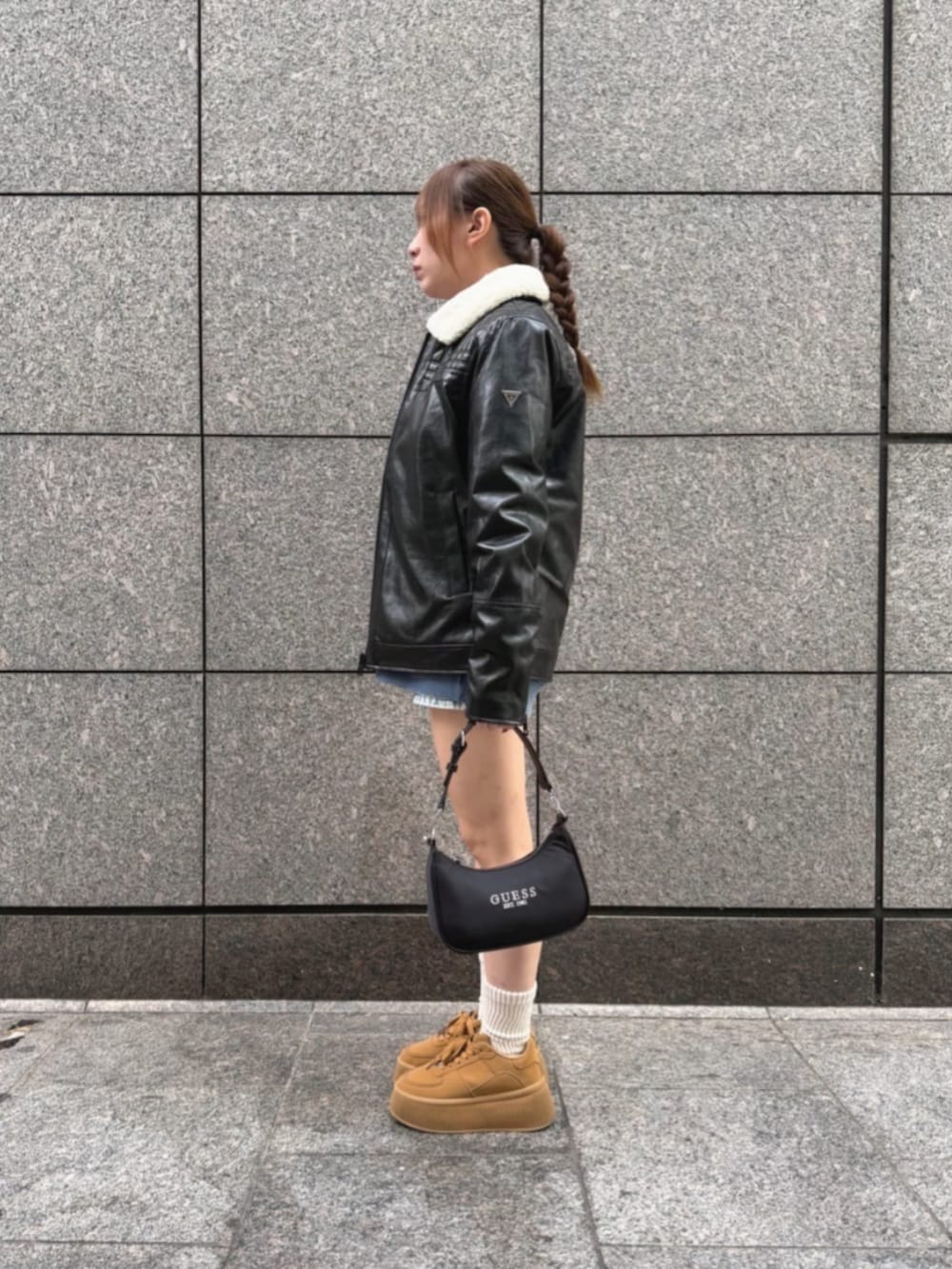 ブルー系のデニムパンツ、ブラック系のショルダーバッグ、ブルー系のスウェットを着用したレディースの冬コーディネートの2枚目の写真