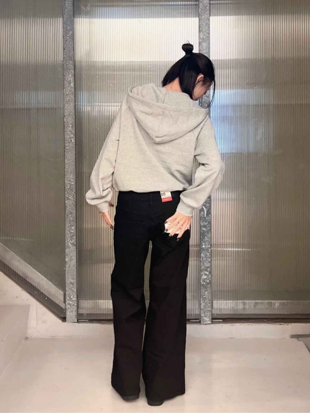 グレー系のパーカー、ブラック系のデニムパンツ、ブルー系のパーカーを着用したレディースの秋コーディネートの5枚目の写真