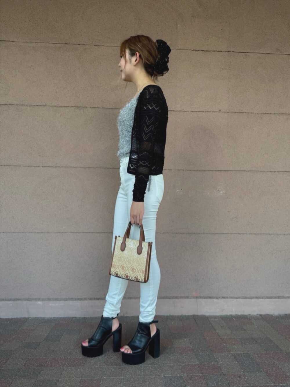 ブラウン系のショルダーバッグ、ホワイト系のデニムパンツ、ブラック系のカーディガン/ボレロを着用したレディースの夏コーディネートの3枚目の写真