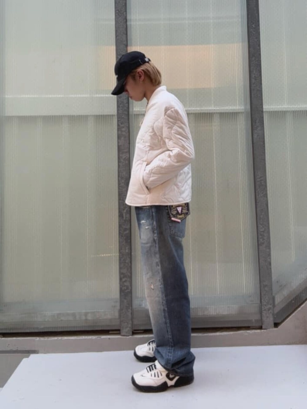 ブルー系のデニムパンツ、ホワイト系のその他アウター、ブラック系のキャップを着用したメンズの秋コーディネートの2枚目の写真