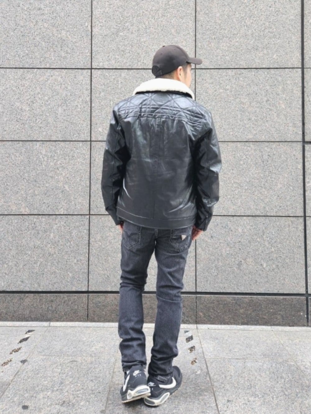 グレー系のデニムパンツ、ブラック系のムートンコートを着用したメンズの秋コーディネートの2枚目の写真