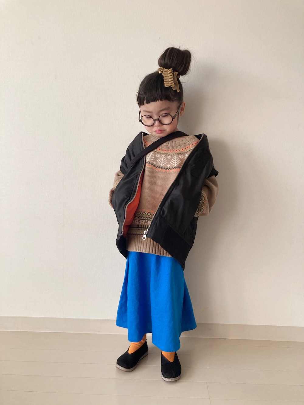 ベージュ系のニット/セーター、ブルー系のスカート、ブラック系のベストを着用したキッズの冬コーディネートの3枚目の写真