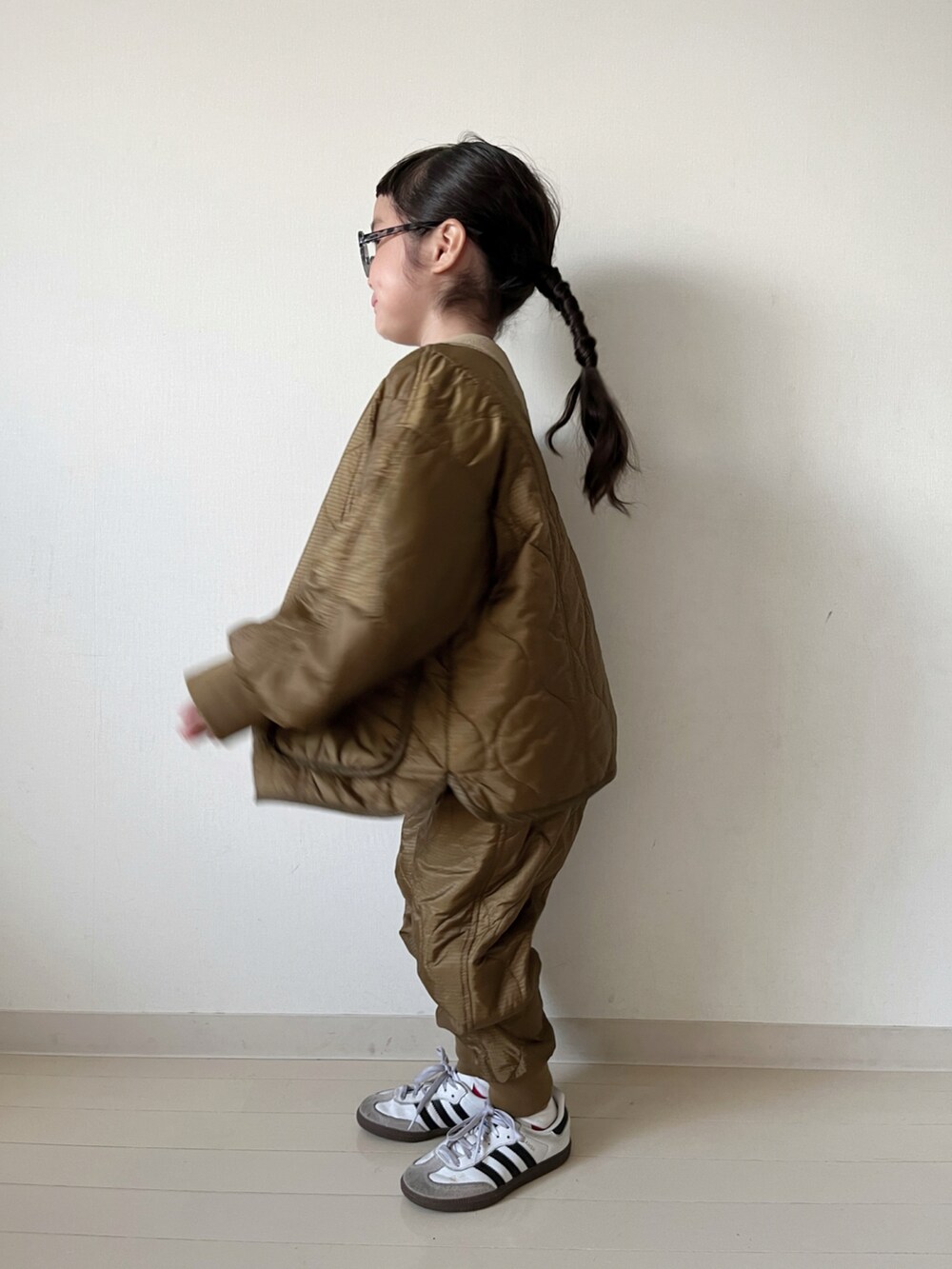 ブラウン系のダウンジャケット/コート、ブラウン系のその他パンツ、ブラック系のTシャツ/カットソーを着用したキッズの秋コーディネートの3枚目の写真