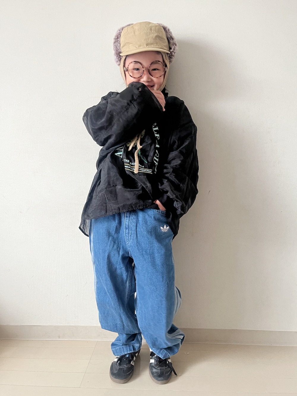 ブラウン系のワンピース、ブラック系のスニーカー、ブラック系のTシャツ/カットソーを着用したキッズの秋コーディネートの2枚目の写真