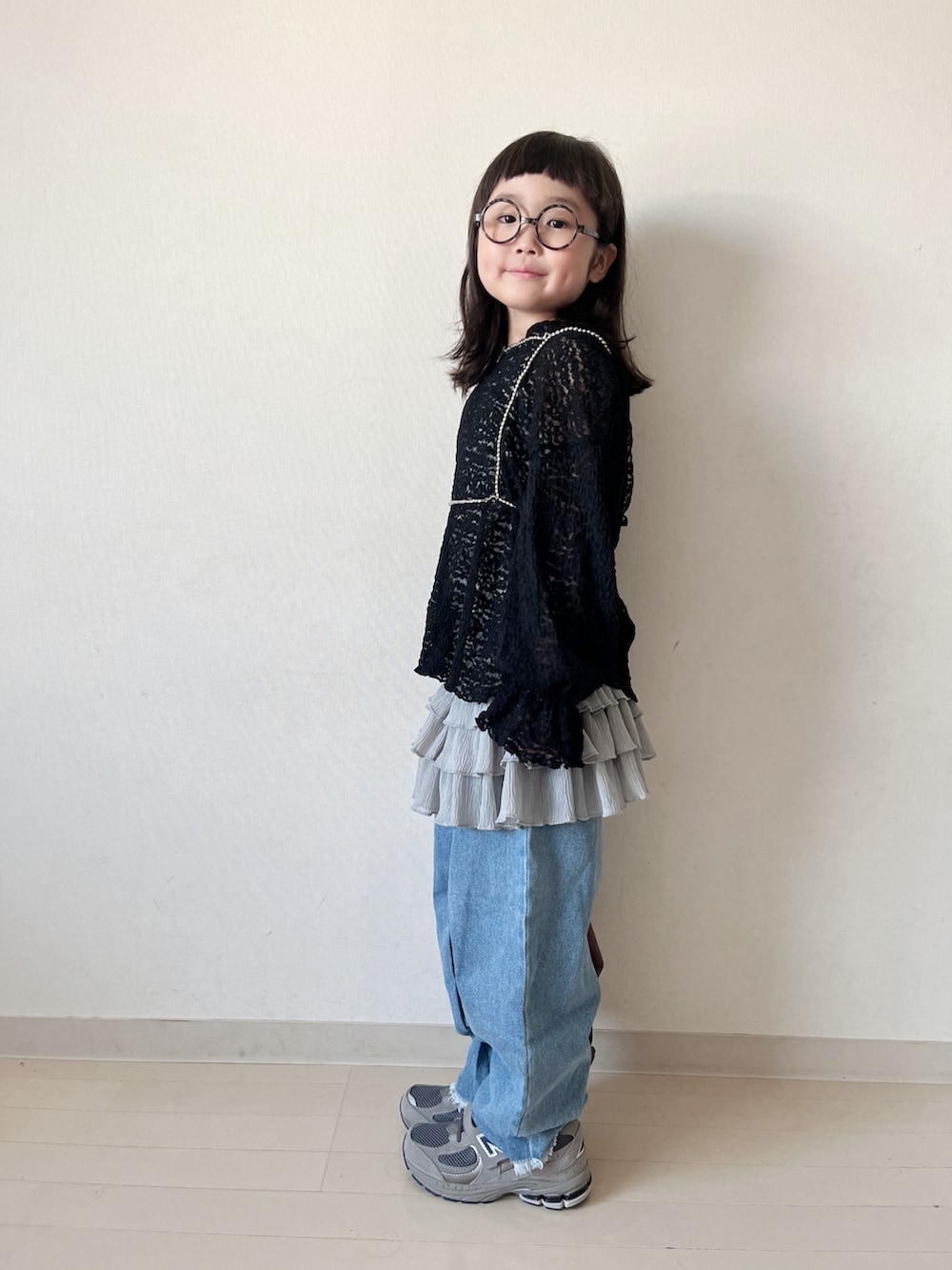 ブラック系のTシャツ/カットソー、ブラウン系のショルダーバッグ、グレー系のスカートを着用したキッズの秋コーディネートの5枚目の写真