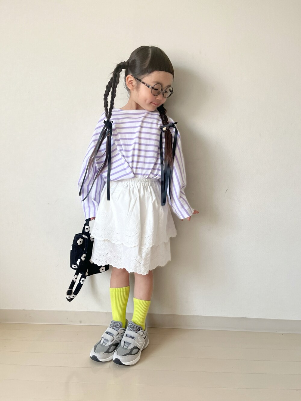 パープル系のTシャツ/カットソー、ホワイト系のスカート、ブラック系のショルダーバッグを着用したキッズの春コーディネートの2枚目の写真