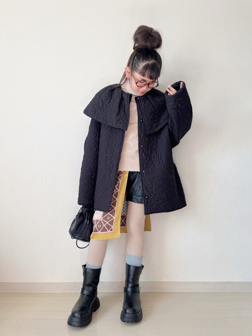 ブラック系のブーツ、ブラック系のその他パンツ、ベージュ系のニット/セーターを着用したキッズの冬コーディネートの3枚目の写真