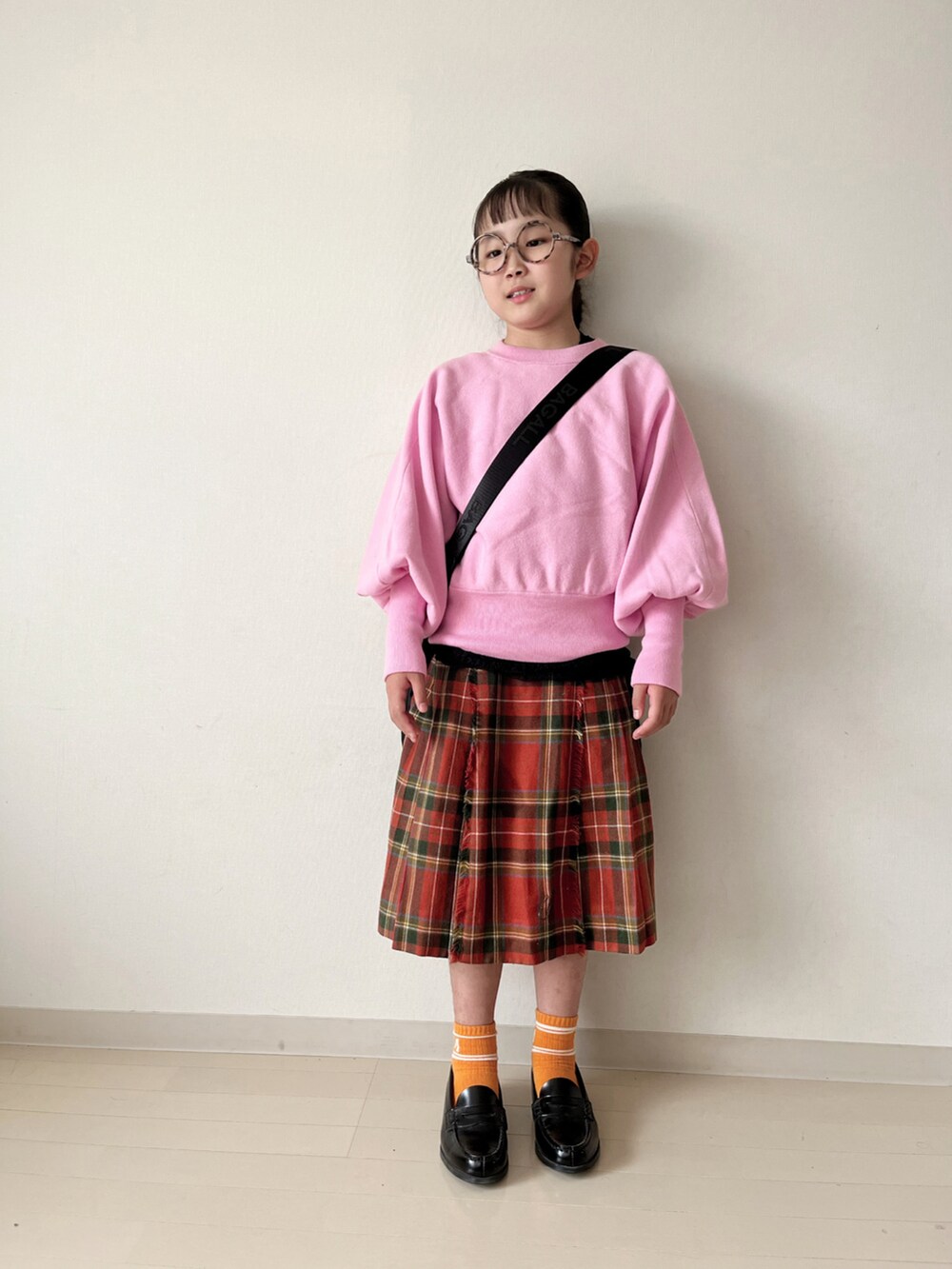 ピンク系のニット/セーター、グリーン系のダウンベスト、ブラック系のローファーを着用したキッズの秋コーディネートの4枚目の写真