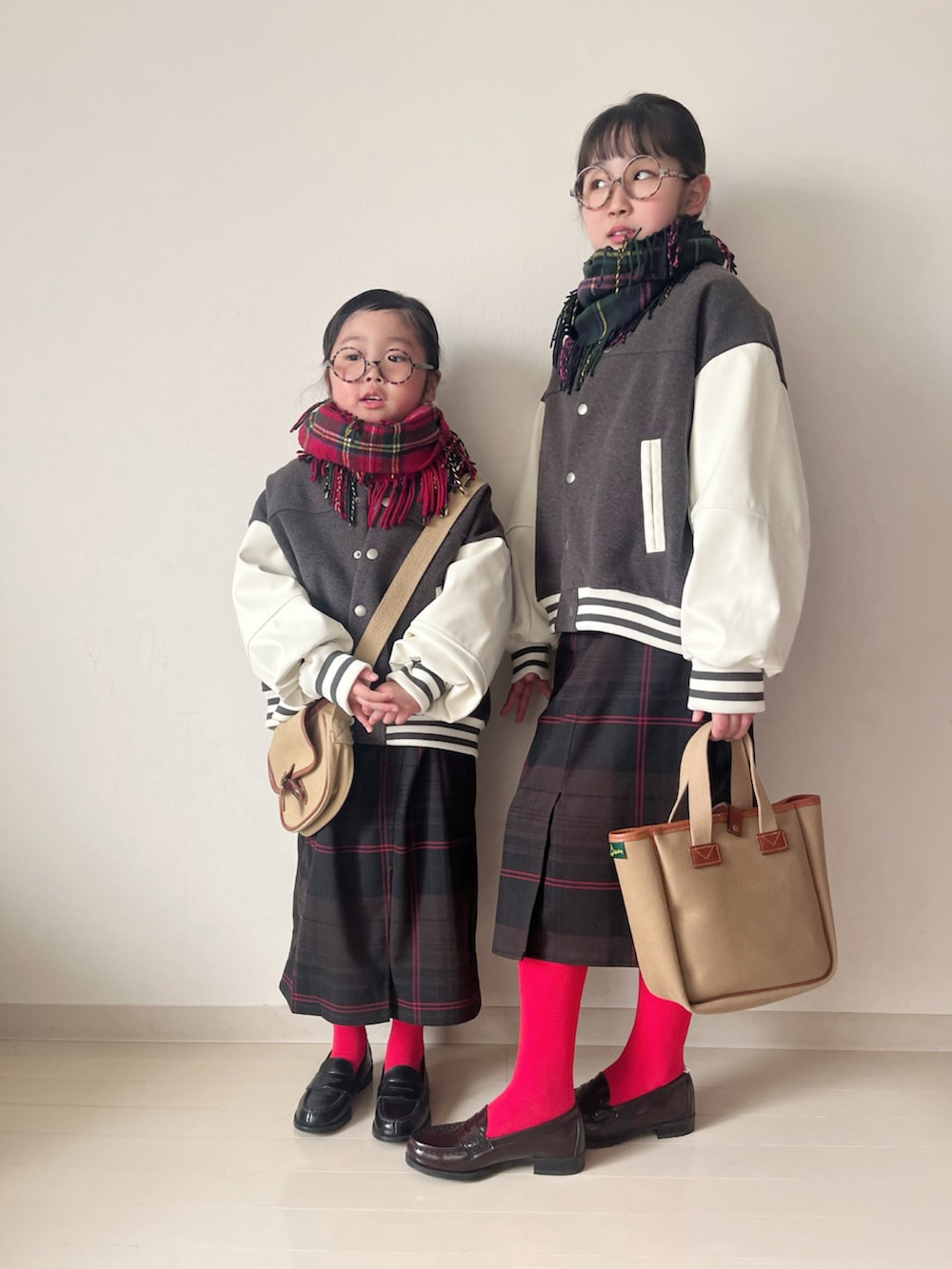 グレー系のスタジャン、グレー系のスタジャン、ホワイト系のニット/セーターを着用したキッズの冬コーディネートの3枚目の写真