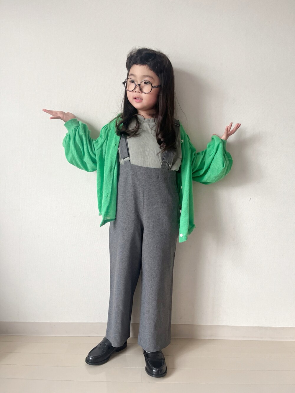 グレー系のワンピース、グリーン系のカーディガン/ボレロ、グリーン系のTシャツ/カットソーを着用したキッズの秋コーディネートの3枚目の写真
