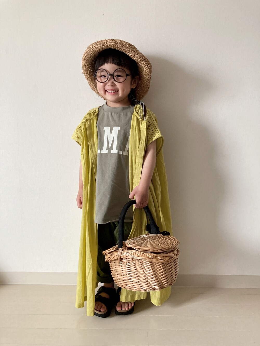 イエロー系のワンピース、グリーン系のTシャツ/カットソー、レッド系のかごバッグを着用したキッズの春コーディネートの5枚目の写真