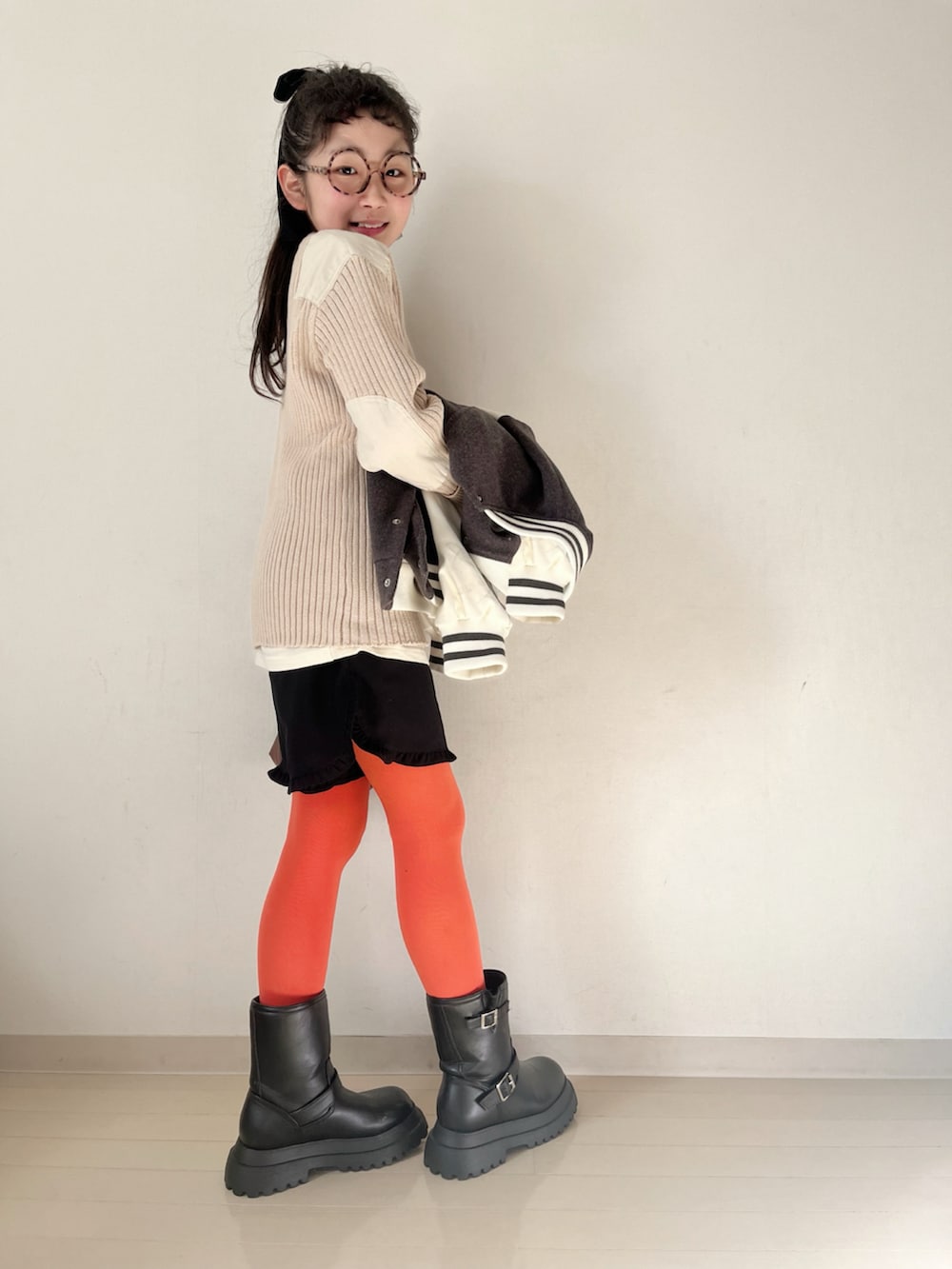 ホワイト系のニット/セーター、ホワイト系のTシャツ/カットソー、グレー系のスタジャンを着用したキッズの秋コーディネートの2枚目の写真