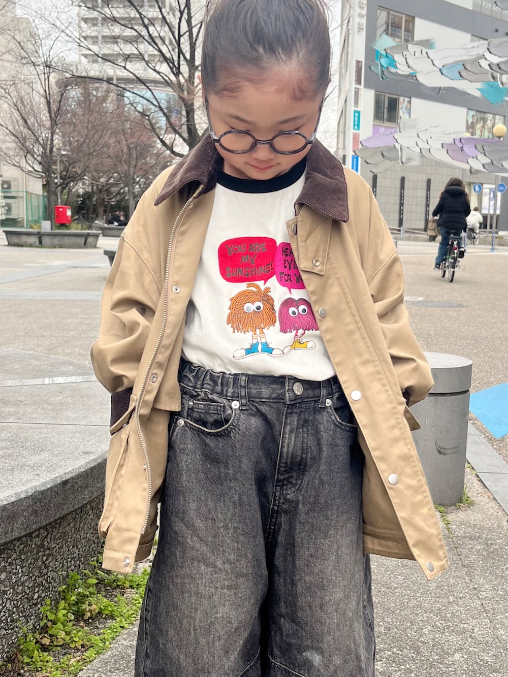 ブラック系のTシャツ/カットソー、ホワイト系のスニーカー、ベージュ系のミリタリージャケットを着用したキッズの春コーディネートの5枚目の写真