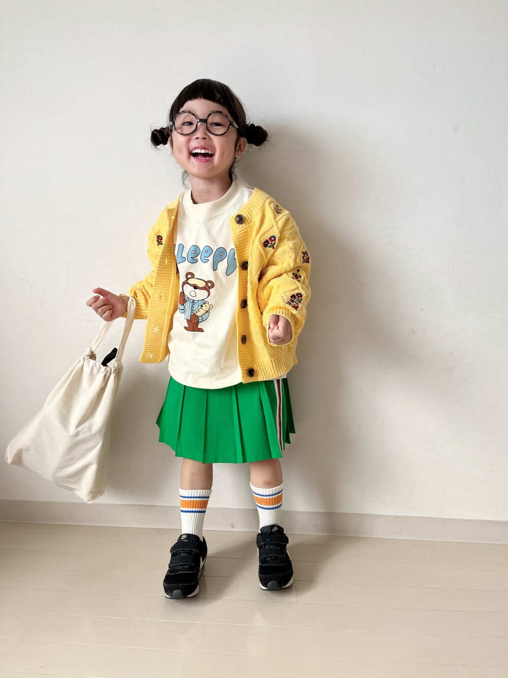 ホワイト系のTシャツ/カットソー、グリーン系のスカート、ブラック系のスニーカーを着用したキッズの秋コーディネートの5枚目の写真