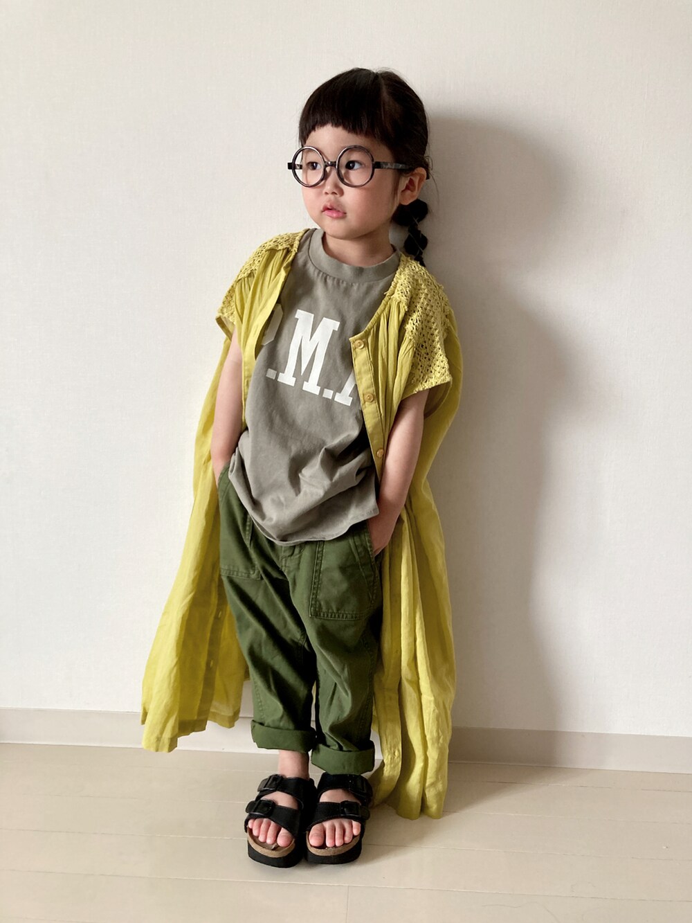 イエロー系のワンピース、グリーン系のTシャツ/カットソー、レッド系のかごバッグを着用したキッズの春コーディネートの4枚目の写真