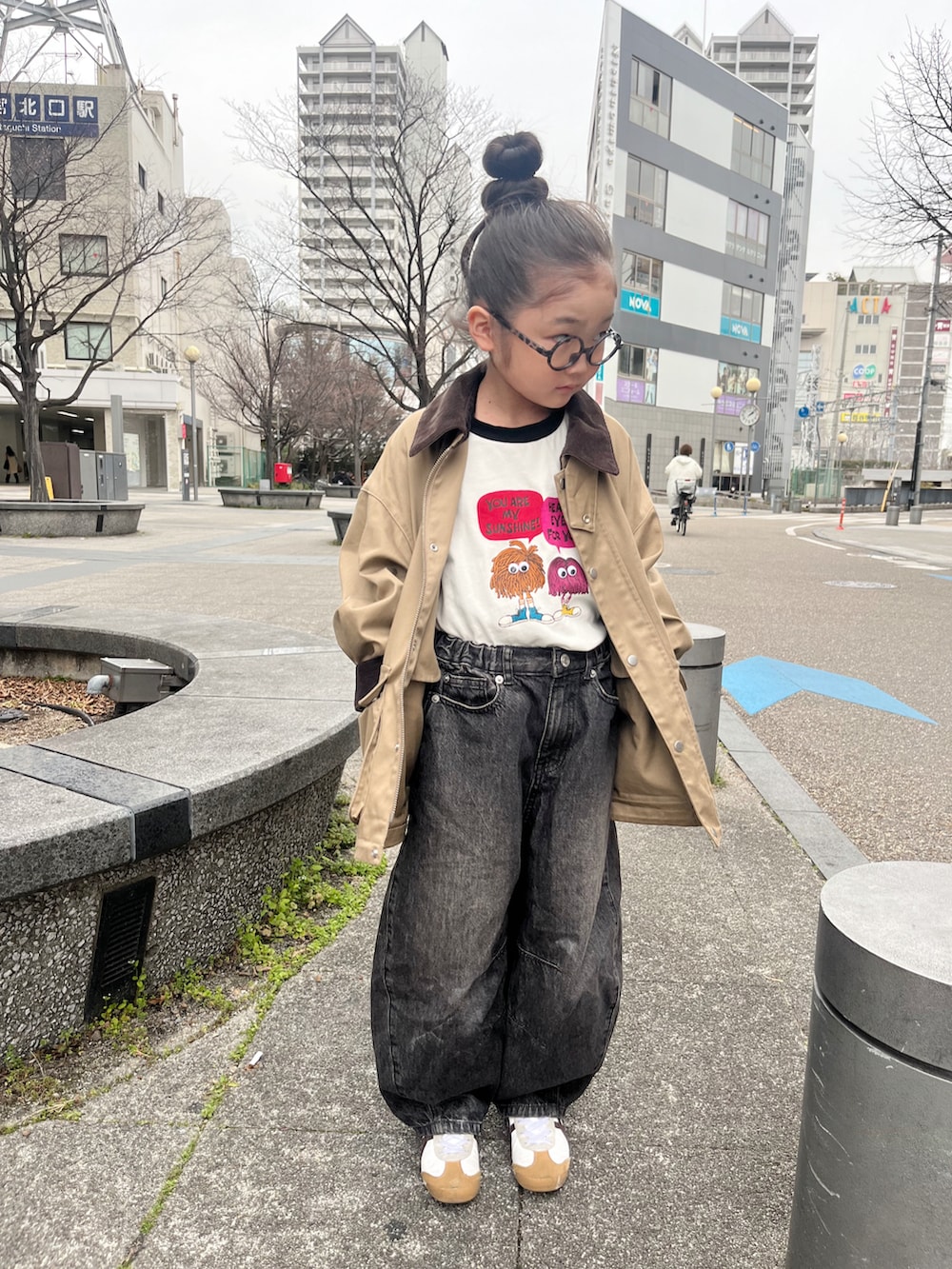 ブラック系のTシャツ/カットソー、ホワイト系のスニーカー、ベージュ系のミリタリージャケットを着用したキッズの春コーディネートの3枚目の写真