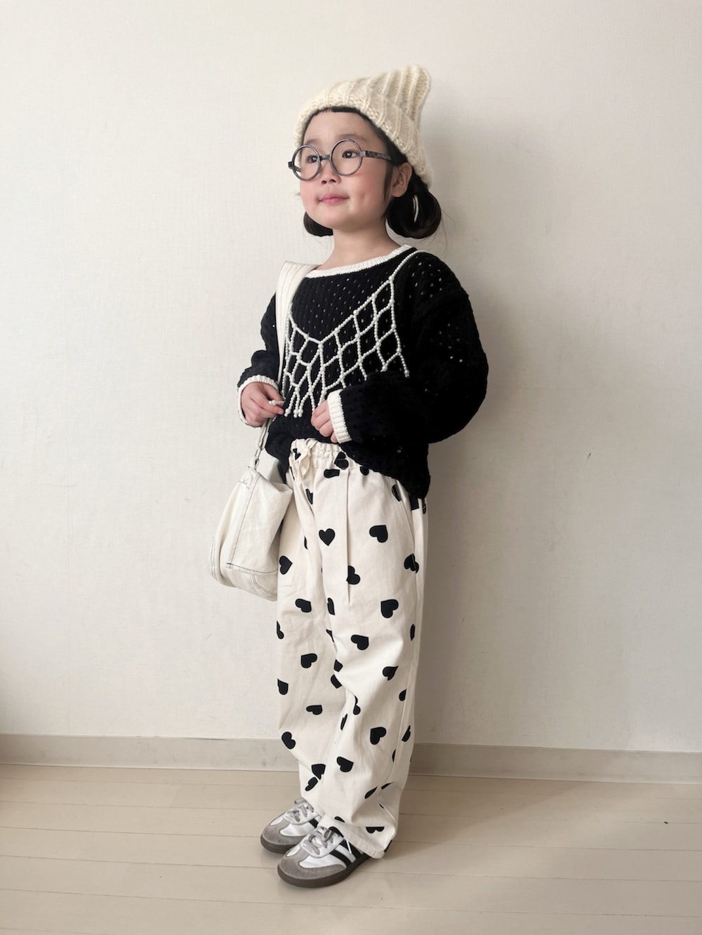 ホワイト系のダウンジャケット/コート、ホワイト系のその他パンツ、ブラック系のニット/セーターを着用したキッズの冬コーディネートの4枚目の写真