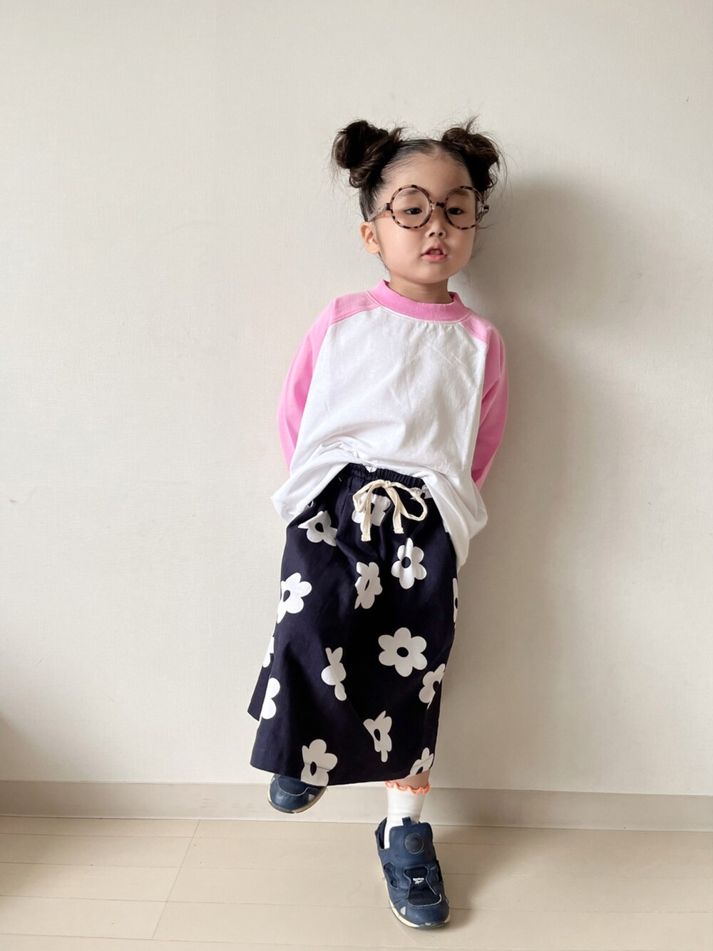 ピンク系のTシャツ/カットソー、ブルー系のスカート、ブルー系のスニーカーを着用したキッズの春コーディネートの2枚目の写真