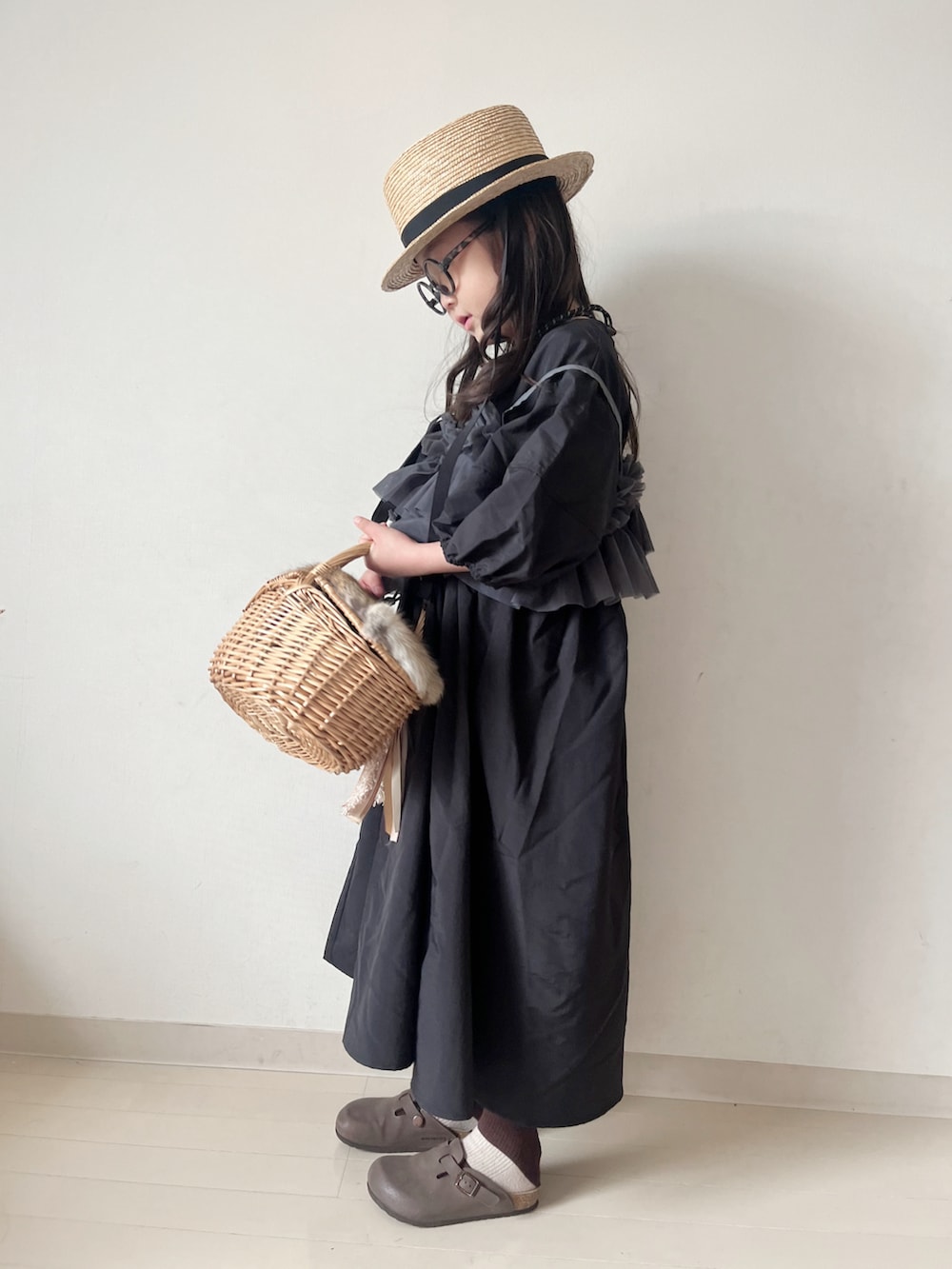 ブラック系のワンピース、ブラウン系のサンダル、ベージュ系のソックス/靴下を着用したキッズの春コーディネートの3枚目の写真