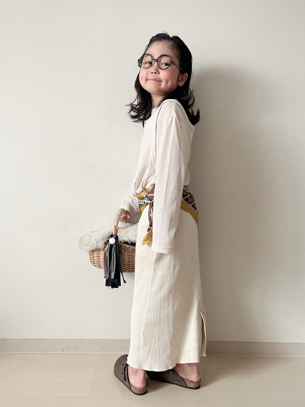 ベージュ系のTシャツ/カットソー、ベージュ系のスカート、イエロー系のバンダナ/スカーフを着用したキッズの秋コーディネートの4枚目の写真